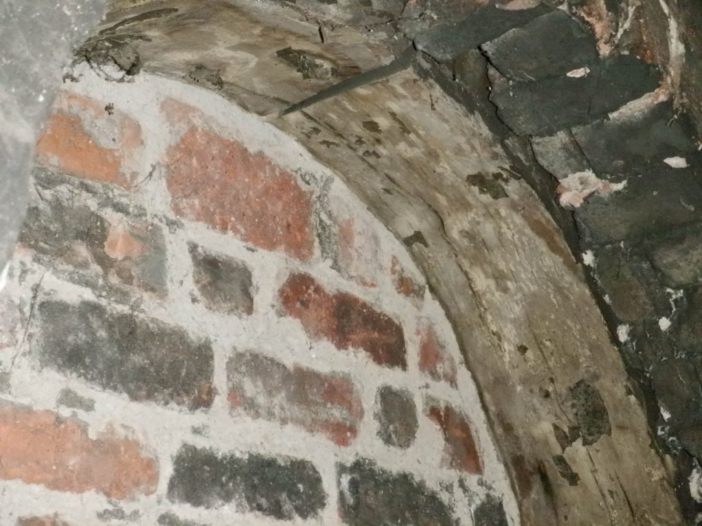 Close up of the bricked up indow's arch lined with wood