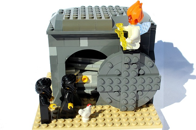 Lego model of  2 ladies looking into an empty tomb - a round lego stone is moved aside with an Angel sat atop.